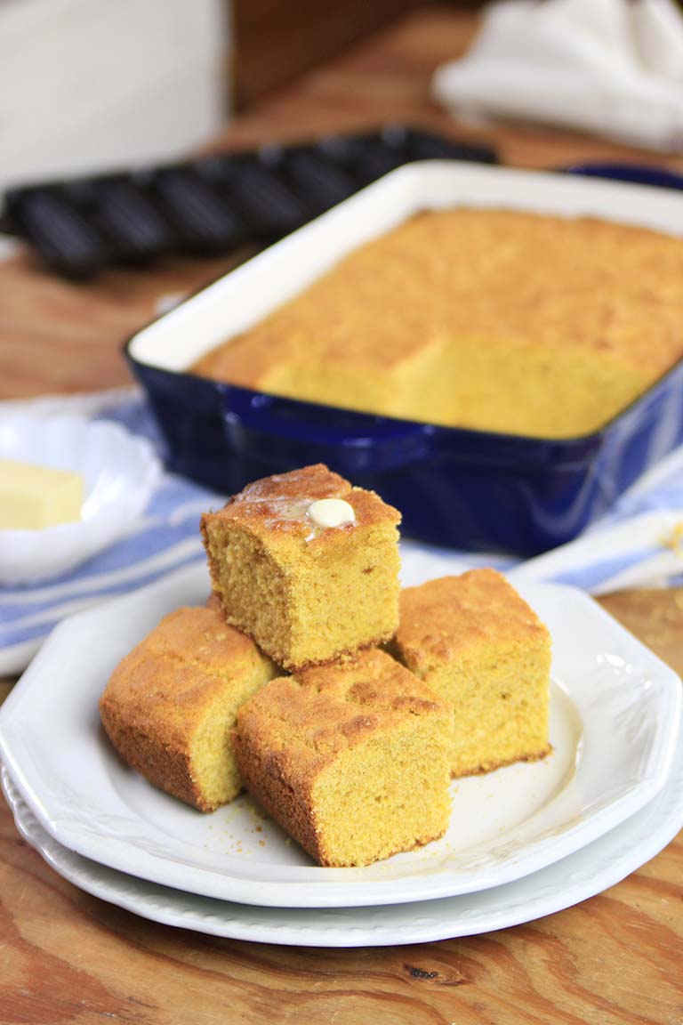 golden cornbread on a plate with melting butter