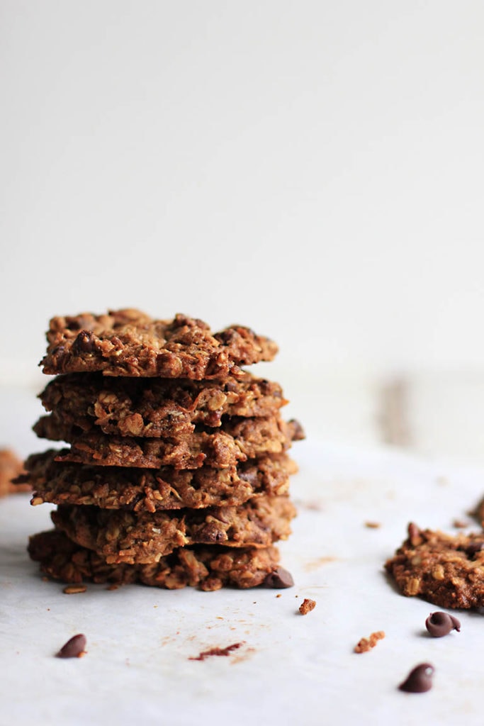 stack of healthy lactation cookies on parchment paper with crumbs