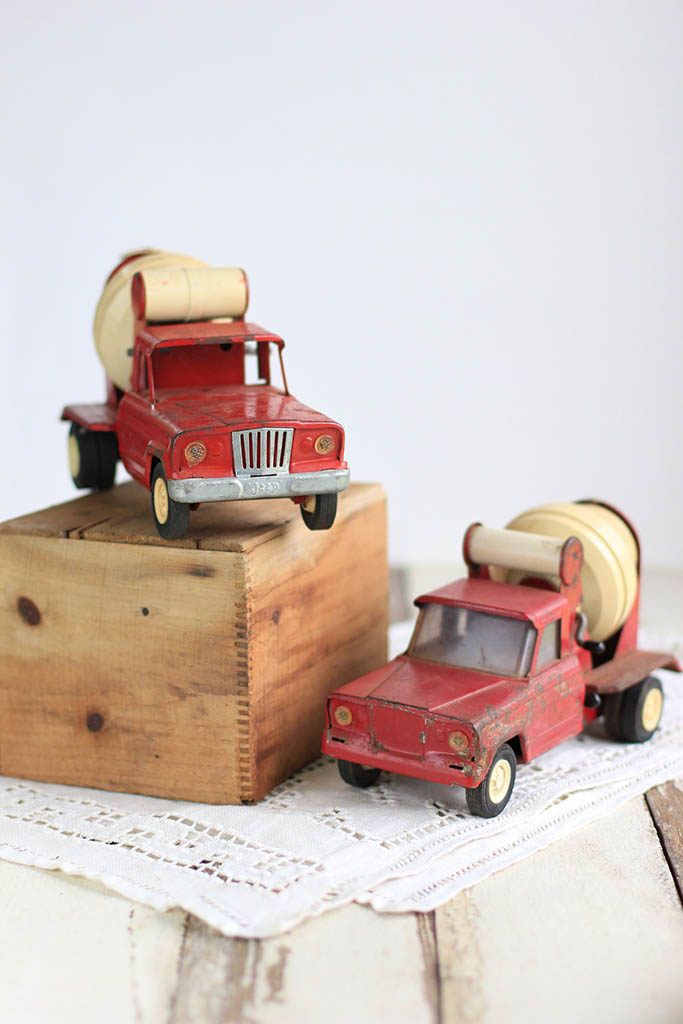Two red metal toy concrete trucks 