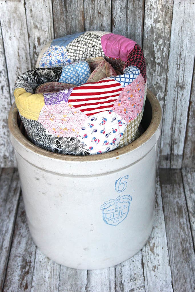 handmade vintage quilt in a six gallon stoneware crock