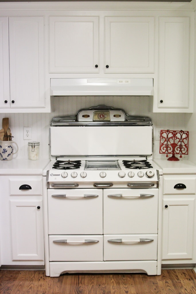 vintage o'keefe and merritt gas range in a all white farmhouse kitchen