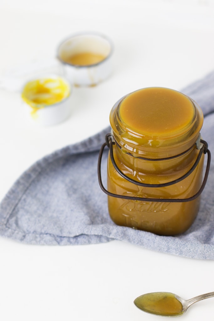 easy honey mustard salad dressing in a glass jar on a blue napkin with a white background