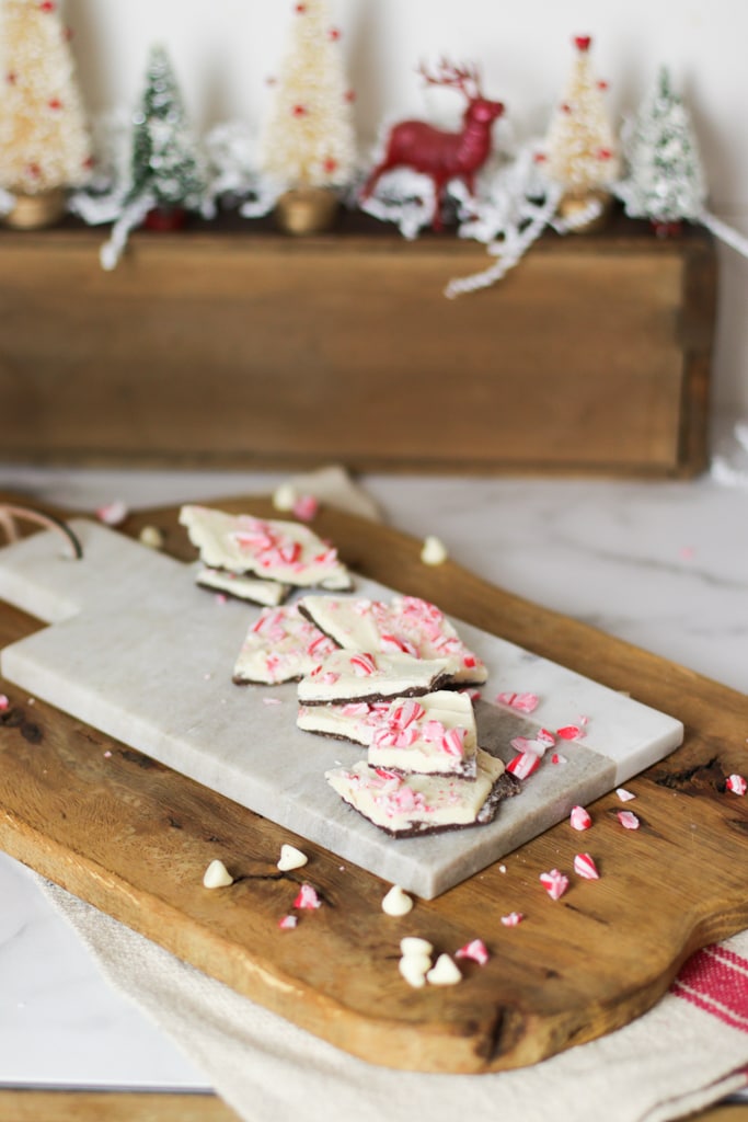 white chocolate peppermint bark in front of a Christmas display of bottlebrush trees and a red reindeer